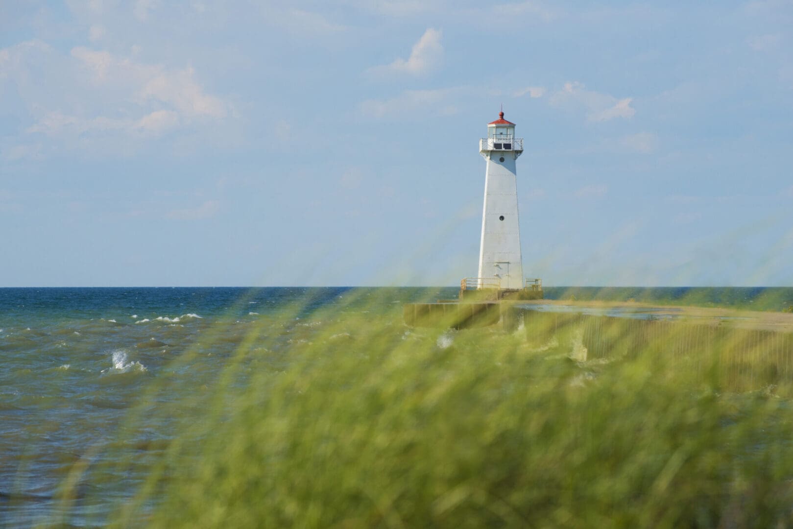 A lighthouse is seen from the water.